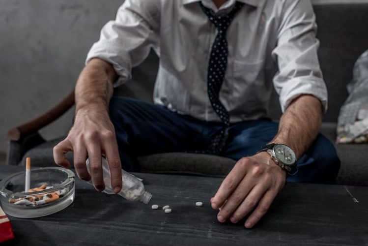 businessman-with-drug-addiction-pouring-pills-on-t-2022-12-16-17-30-07-utc (1)